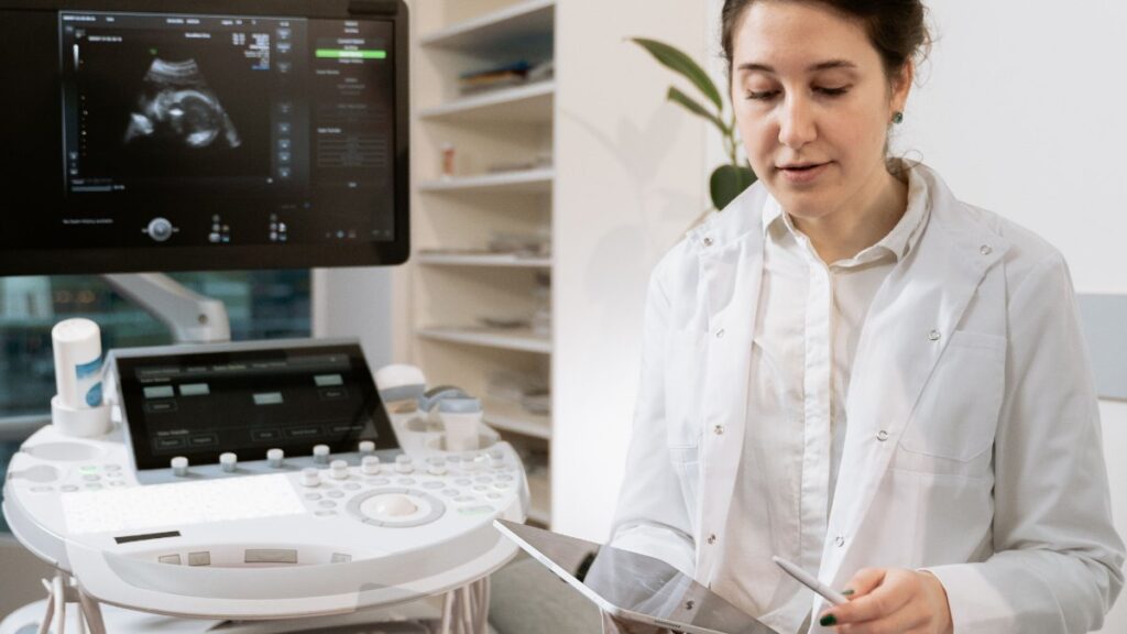 Medica realizando exame de ultrassom em consultorio