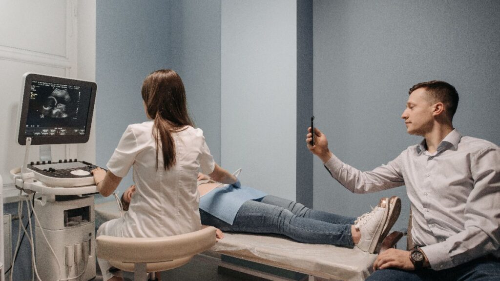 Angiologista realizando ultrassom na perna do paciente